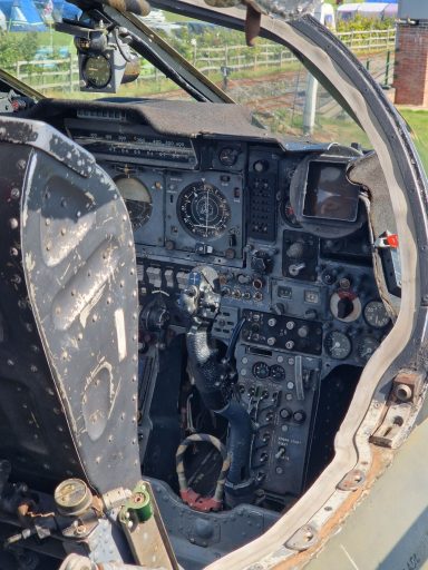 Cockpit of a military aircraft featuring numerous buttons, controls, and instruments.