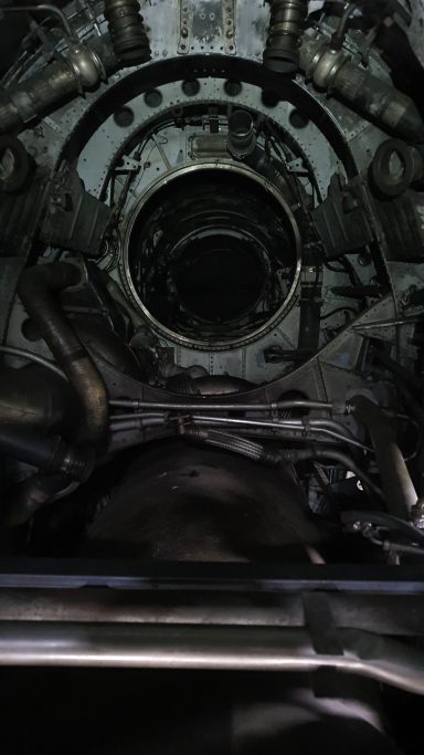 View into a complex engine chamber with metallic components and dark surfaces.