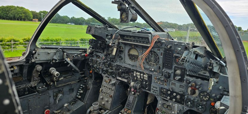 Cockpit interior of an aircraft with visible controls and instruments.